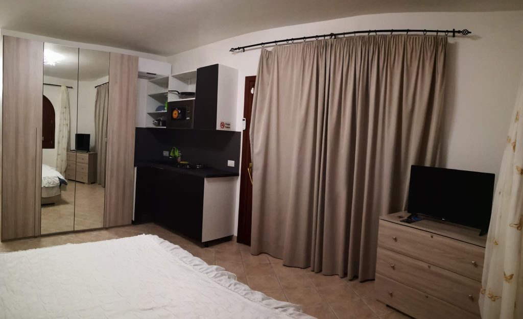 Общий вид студии Home со шкафом, кухней, TV и зоной сна